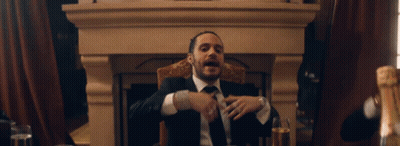 Man In Suit At Table With Champagne Glasses GIF