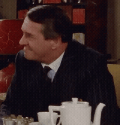 Man In Suit At Table With White Teapot GIF