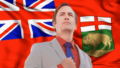 Man In Suit Before British And Canadian Flags GIF