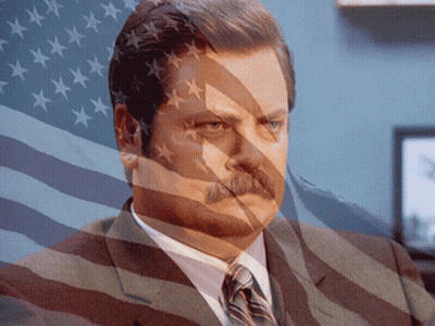 Man In Suit Behind American Flag GIF