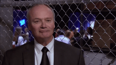 Man In Suit Behind Fence GIF