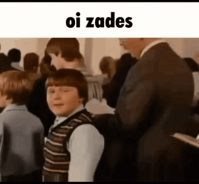 Man In Suit Beside Boy In Striped Vest GIF