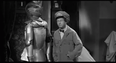 Man In Suit Beside Knight In Armor GIF