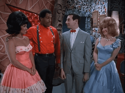 Man In Suit Between Women In Pink And Man In Red GIF