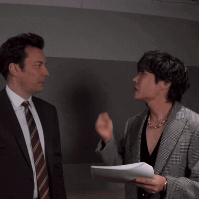 Man In Suit Blowing Kiss To Man In Plaid Jacket GIF