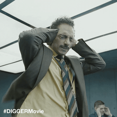 Man In Suit Covering Ears While Another Man Looks On GIF