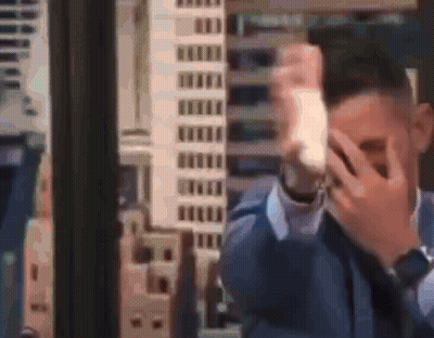 Man In Suit Covering Face With Hands GIF