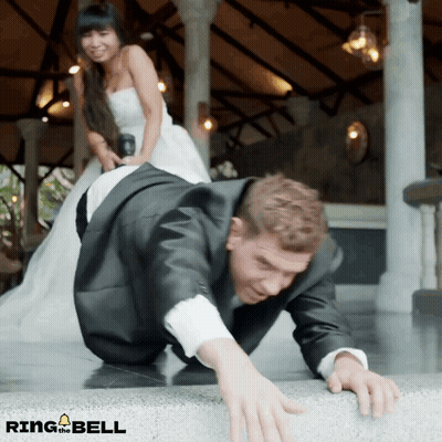 Man In Suit Crawling, Woman In Wedding Dress Standing Behind GIF