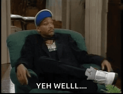Man In Suit Crossed Legs Saying Yeh Well GIF