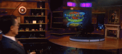 Man In Suit Dancing Before Super Colbchol Sign GIF