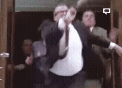 Man In Suit Dancing In Elevator With Others GIF