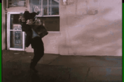 Man In Suit Dancing In Front Of Building With Green Border GIF