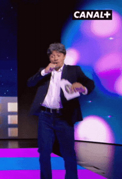 Man In Suit Dancing In Front Of Canal+ Sign GIF