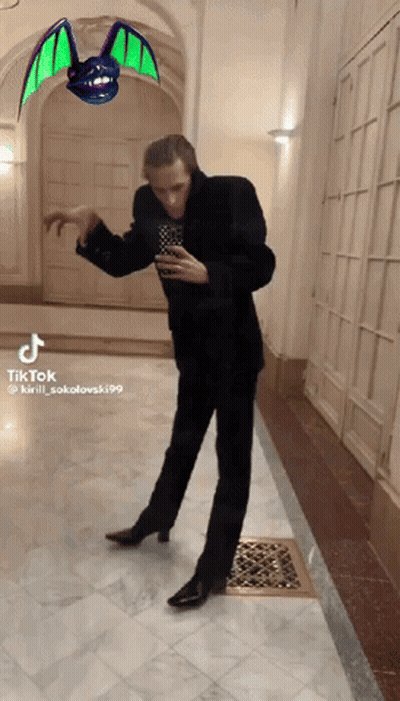 Man In Suit Dancing In Hallway With Bat GIF