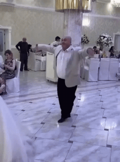 Man In Suit Dancing In Room With People Sitting GIF