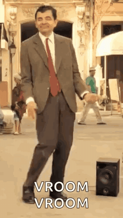 Man in Suit Dancing Next to Speaker