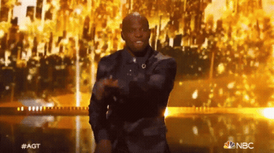 Man In Suit Dancing On Stage With NBC Logo GIF