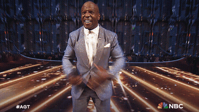 Man In Suit Dancing On Stage With NBC Logo GIF