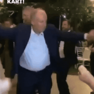 Man In Suit Dancing With Arms Outstretched In Crowd GIF