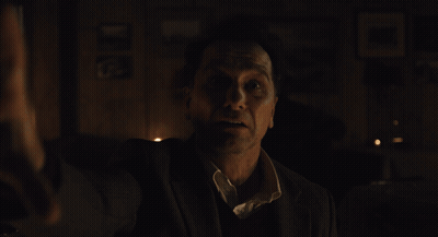 Man In Suit Dark Room With Saint Picture GIF