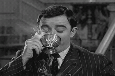 Man in Suit Drinking Silver Cup
