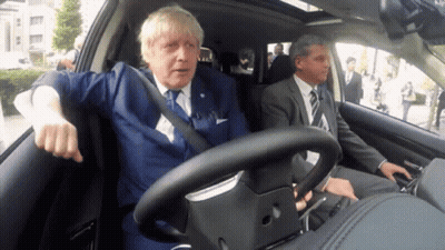 Man In Suit Driving Car With Another Man In Back GIF