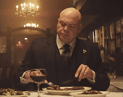 Man In Suit Eating At Table GIF