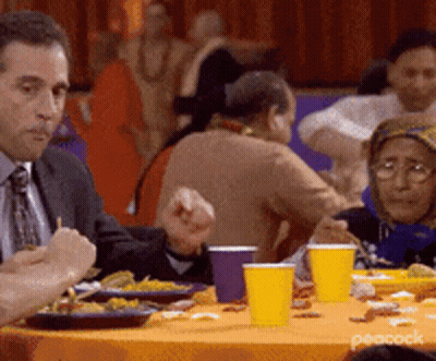 Man In Suit Eating Food At Table GIF