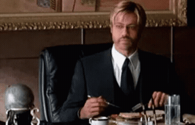 Man In Suit Eating Meal At Table GIF