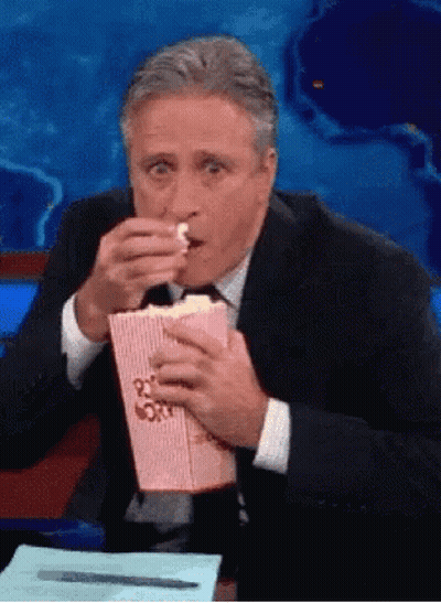 Man In Suit Eating Popcorn From Pink Box GIF
