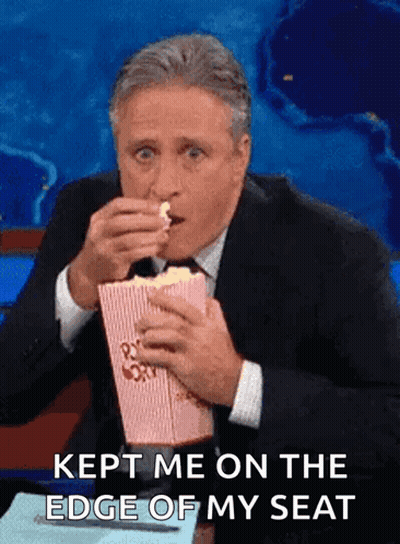 Man In Suit Eating Popcorn Saying Kept Me On The Edge Of My Seat GIF
