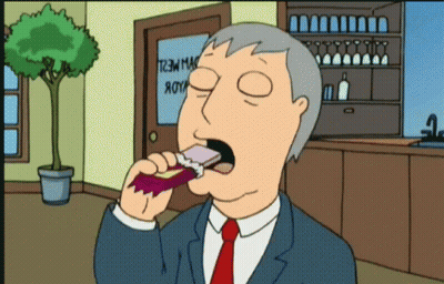 Man In Suit Eating Snack In Front Of T2M Mac Door GIF