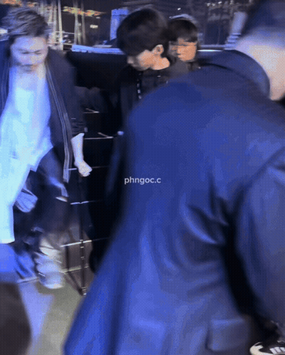 Man In Suit Escorted By Man In Black Jacket Saying Phngoc.C GIF