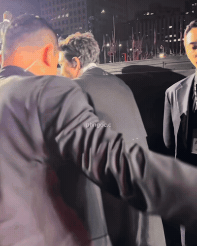 Man In Suit Escorted By Man In Black Jacket Saying Phngoc.C GIF