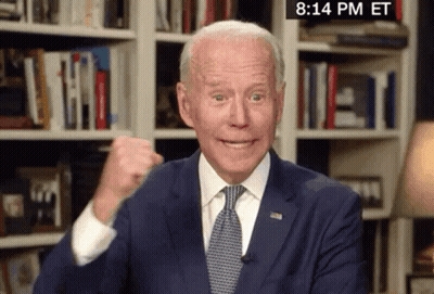 Man In Suit Giving Fist Bump In Front Of Bookshelf Saying 8:14 PM ET GIF