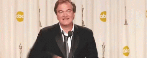 Man In Suit Giving Peace Sign At Microphone GIF