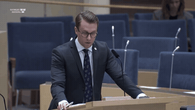 Man In Suit Giving Speech At Sveriges Riksdag Podium GIF