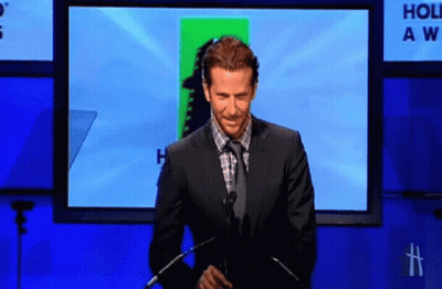 Man In Suit Giving Speech In Front Of Holiday Awards Screen GIF