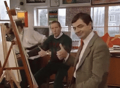 Man In Suit Giving Thumbs Up In Front Of Easel GIF