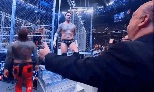 Man In Suit Giving Thumbs Up To Wrestler GIF