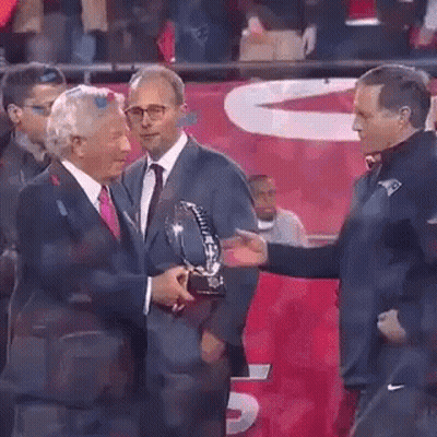Man In Suit Giving Trophy To Another Man GIF