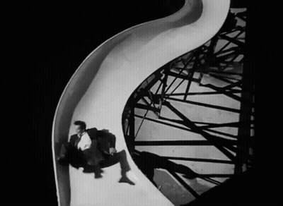 Man In Suit Going Down Slide Black And White GIF