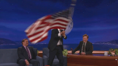 Man In Suit Holding American Flag Before Full Moon GIF