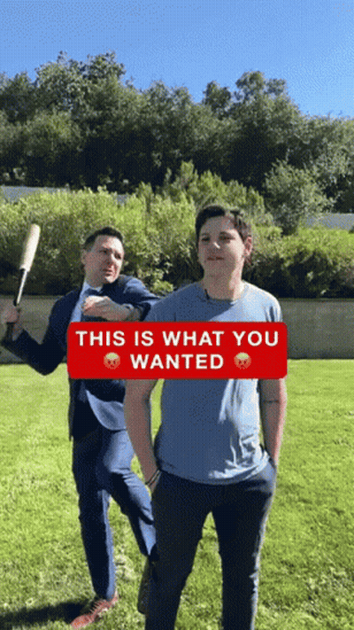 Man In Suit Holding Baseball Bat Next To Boy In Blue Shirt GIF