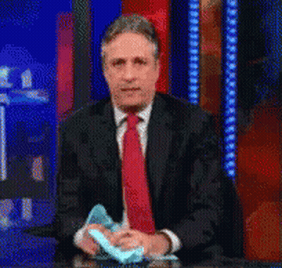 Man In Suit Holding Blue Object GIF