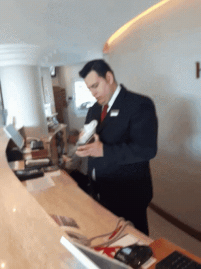 Man In Suit Holding Book At Counter GIF
