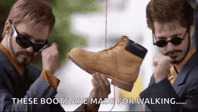 Man In Suit Holding Boots GIF