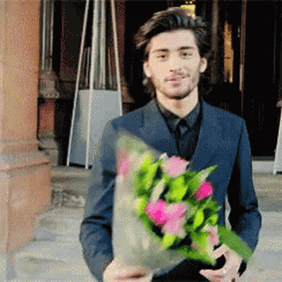Man In Suit Holding Bouquet Of Flowers GIF