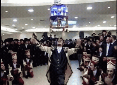Man In Suit Holding Chandelier Over Head GIF