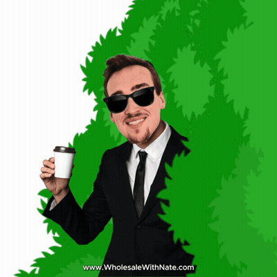 Man In Suit Holding Coffee Behind Green Bush GIF